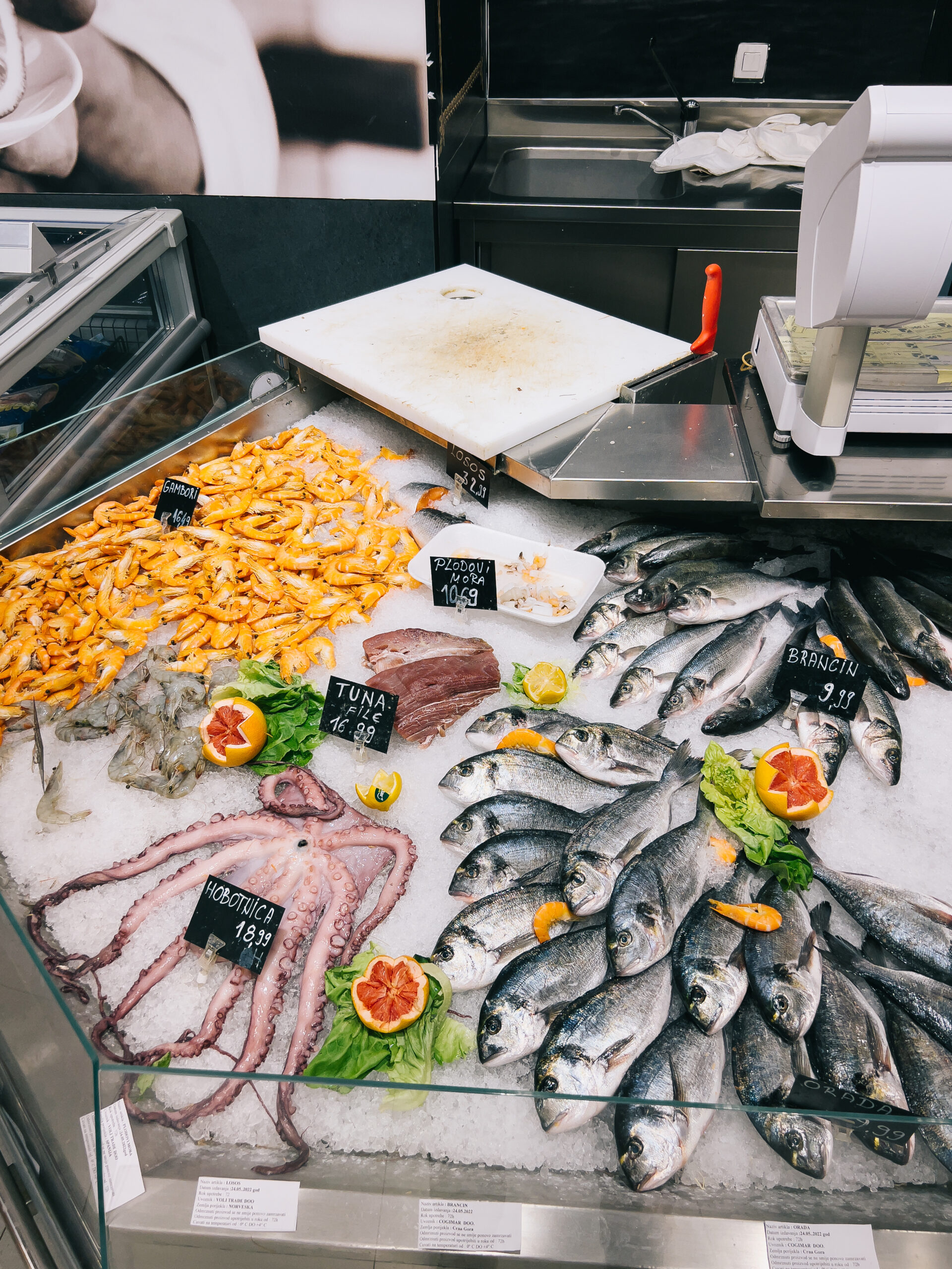 Octopus, tuna, sea bass, seafood, shrimps lie in ice on a shop window